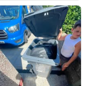 Crew member emptying a household bin into the van